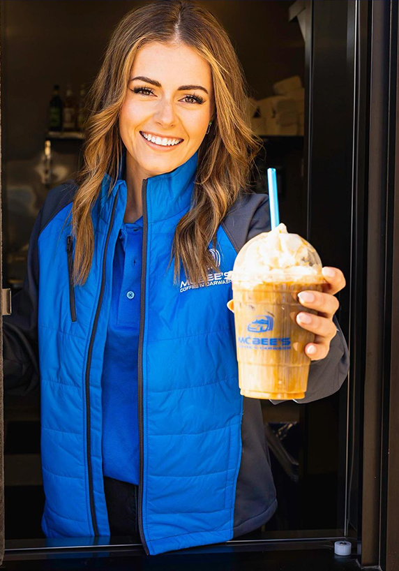 McBee employee handing coffee beverage out car wash window